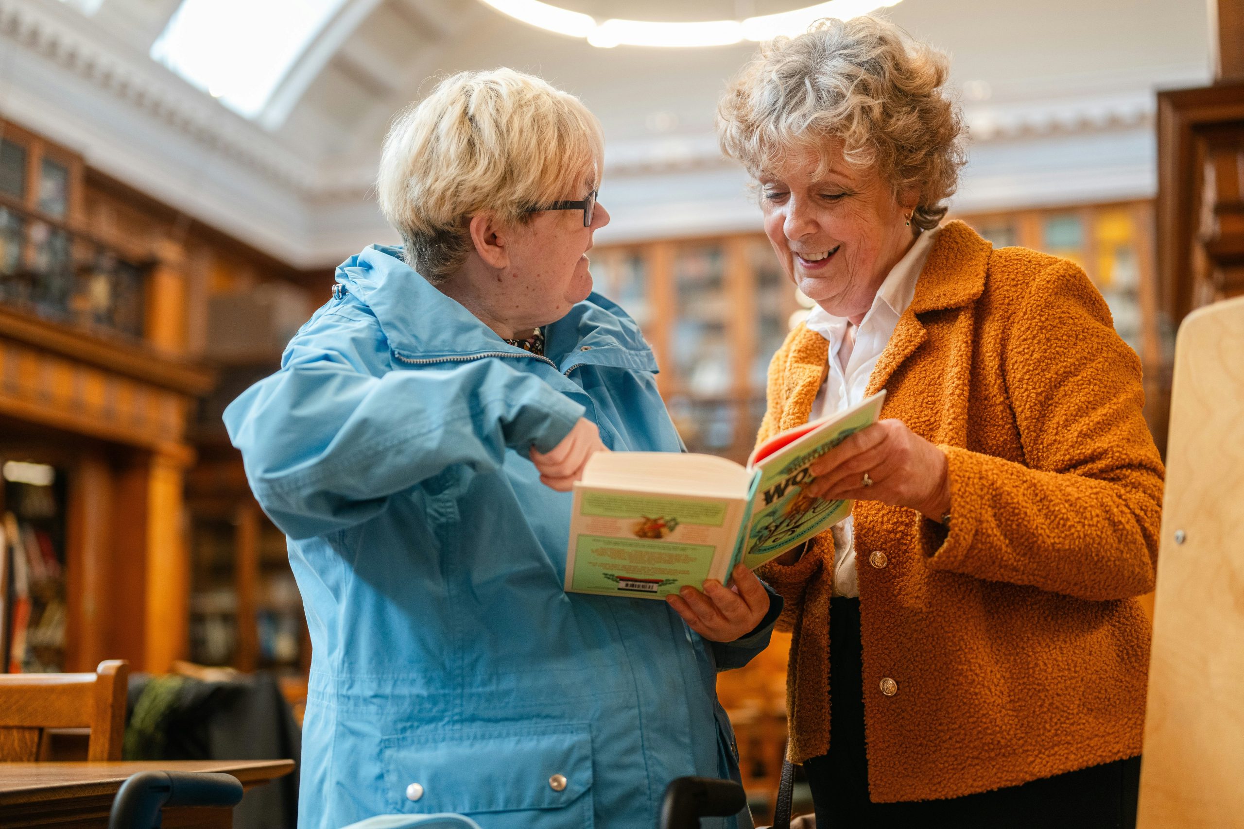 A photo shows two people reading a book together.